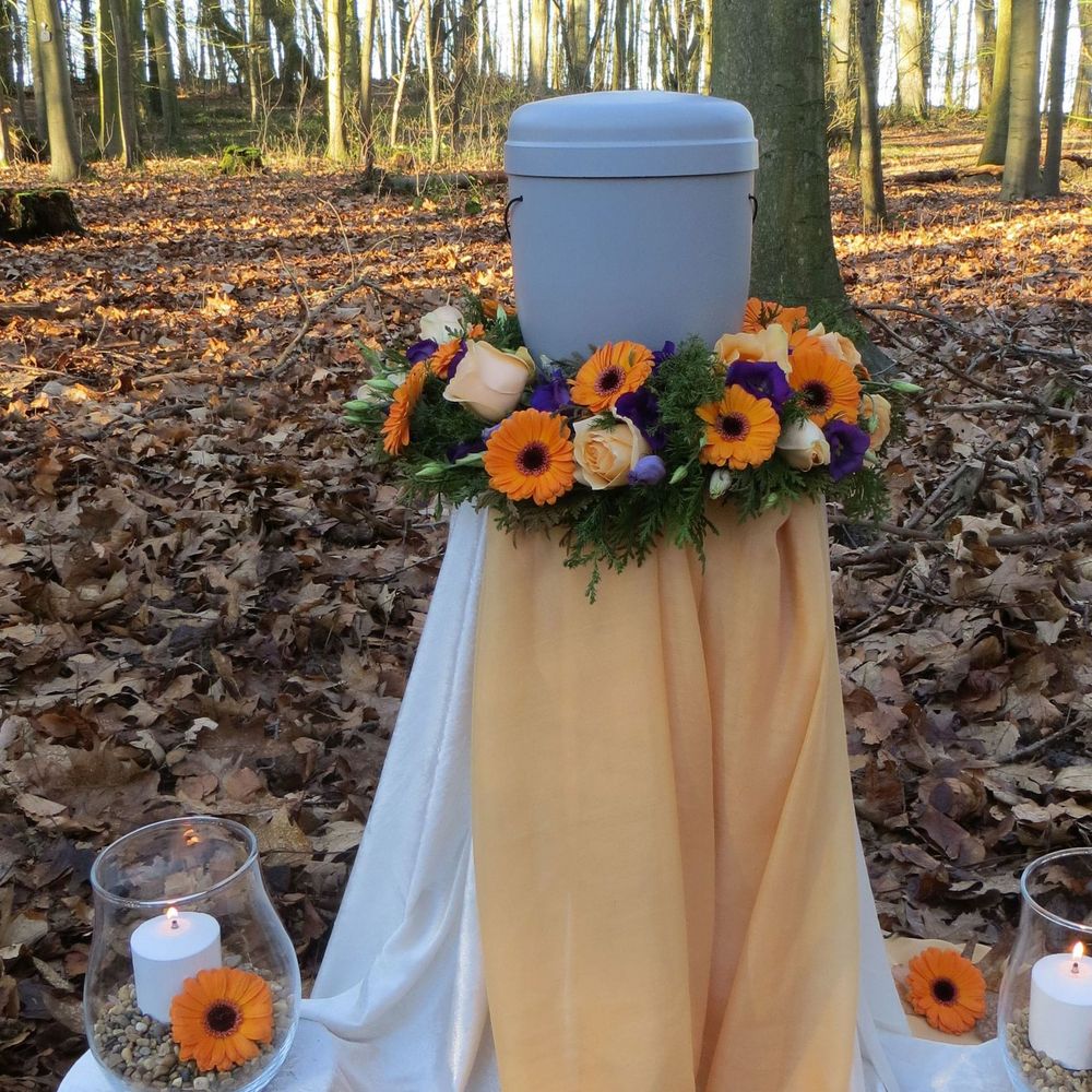 Urne mit Trauerkranz aus orangefarbenen und apricotfarbenen Blumen