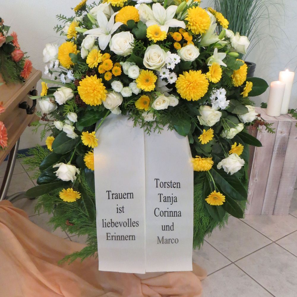 Trauergesteck mit weißen und gelben Blumen