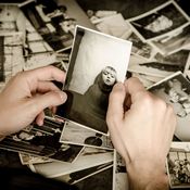 Trauernder wählt alte Bilder für das Erinnerungsbuch aus