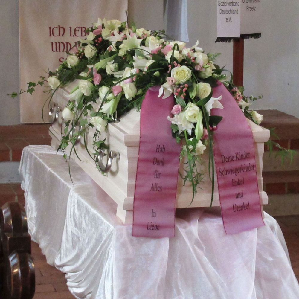 Trauerfloristik: Sargdekoration mit weißen und rosafarbenen Blumen